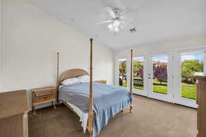 Bedroom featuring dark colored carpet, access to exterior, lofted ceiling, and a ceiling fan