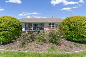 Single story home with covered porch, roof with shingles, and stucco siding