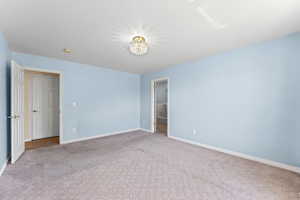 Unfurnished bedroom with carpet and ensuite bath