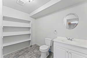 Bathroom with vanity, a textured ceiling, and a closet