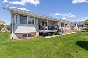 Rear view of property with stucco siding, a lawn, and a mountain view
