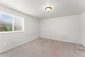 Carpeted spare room with baseboards and a textured ceiling