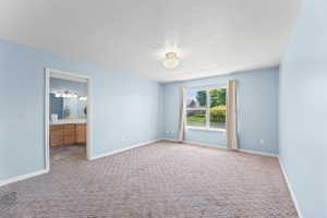 Unfurnished bedroom with carpet flooring and ensuite bath