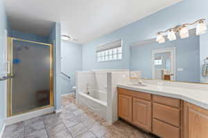 Full bathroom with vanity, a garden tub, a stall shower, and light tile patterned floors