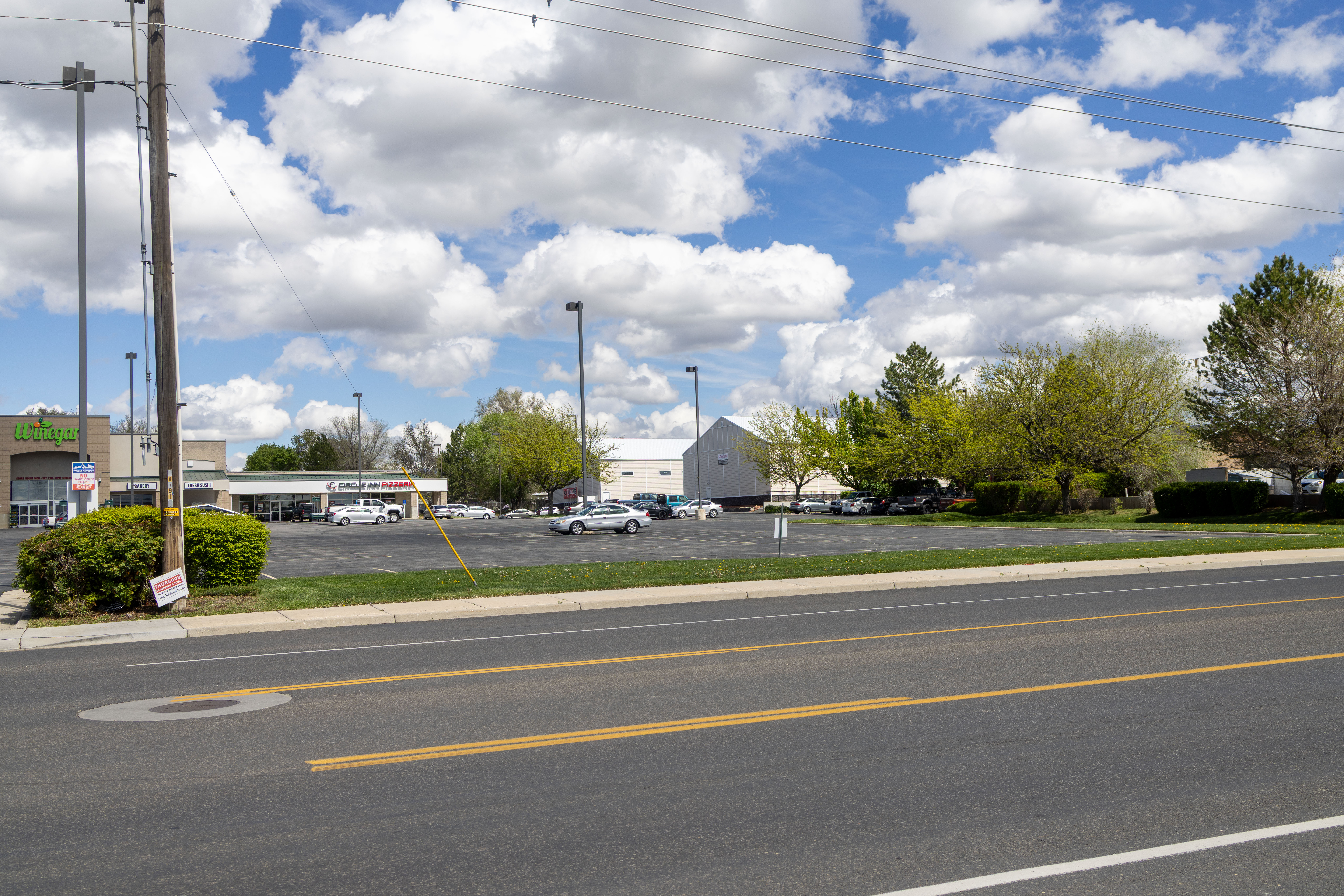 View of asphalt street featuring curbs and sidewalks