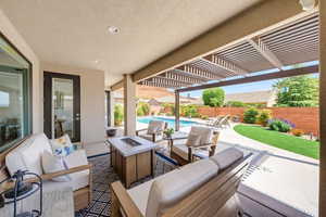 Fenced backyard with an outdoor living space with a fire pit, a pergola, and a patio