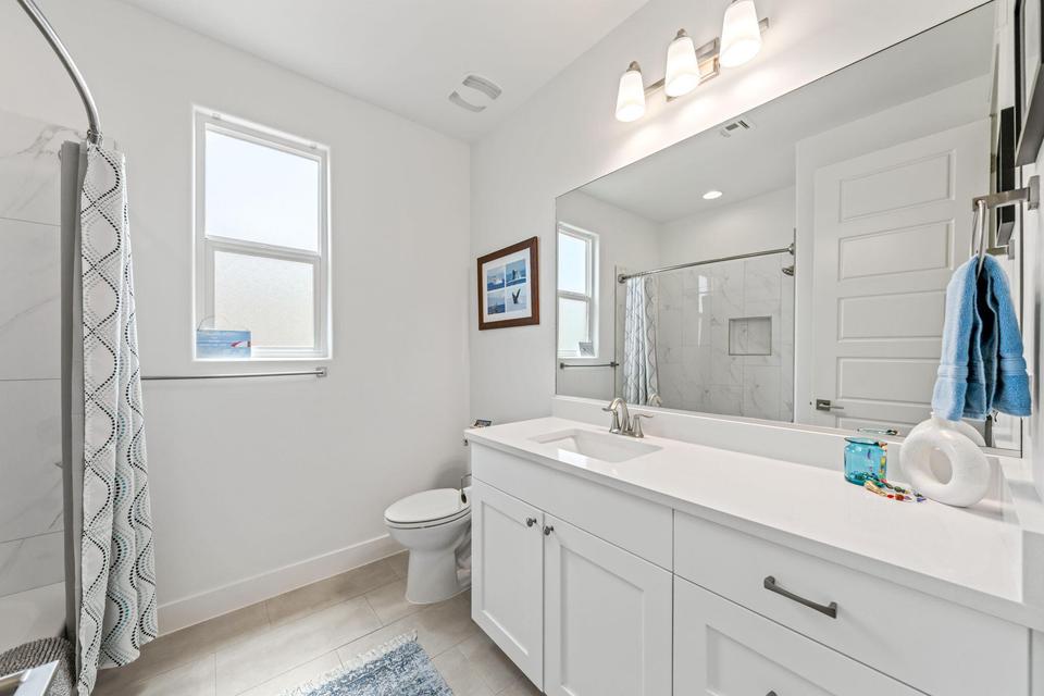 Full bath with vanity, curtained shower, and light tile patterned flooring