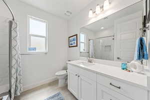 Full bath with vanity, curtained shower, and light tile patterned flooring