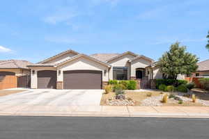 Ranch-style house featuring a gate, a garage, stone siding, and stucco siding