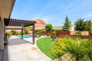 Fenced backyard with a pergola and a patio