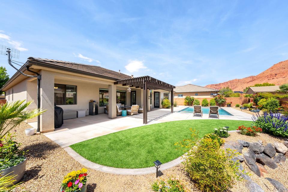 Rear view of house with a pergola, a patio, stucco siding, and a fenced backyard