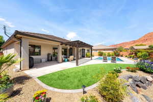Rear view of house with a pergola, a patio, stucco siding, and a fenced backyard