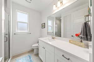Bathroom with vanity, a shower stall, and light tile patterned flooring
