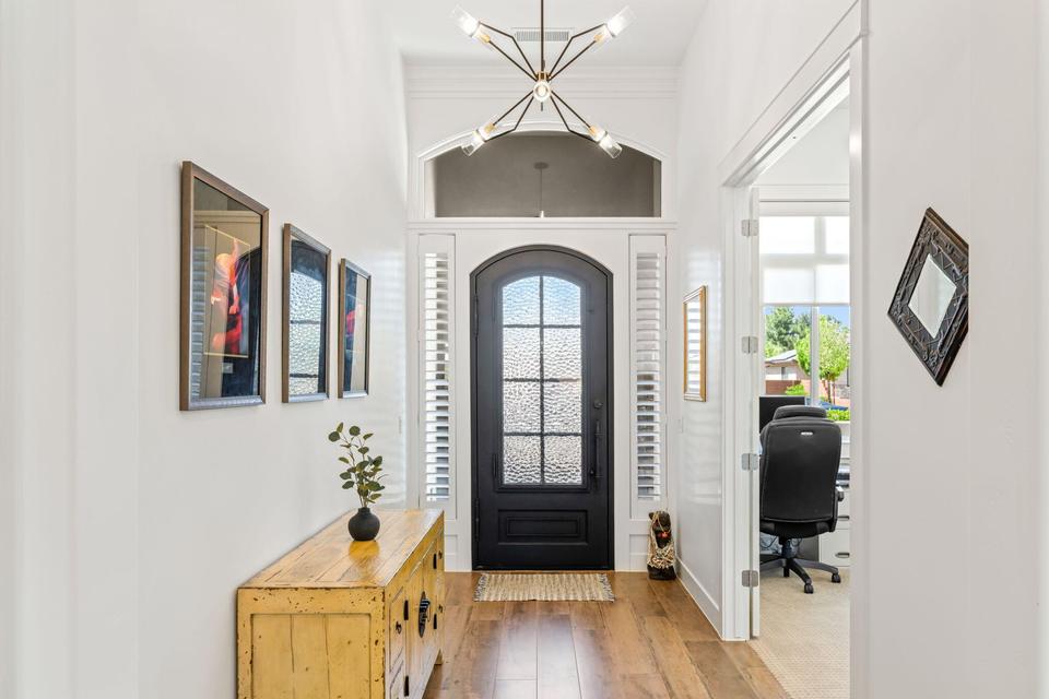 Foyer entrance featuring light wood-style flooring, a chandelier, and ornamental molding