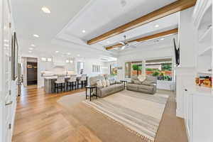 Living area with recessed lighting, beamed ceiling, a ceiling fan, and light wood-style flooring
