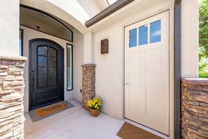 Property entrance featuring stone siding and stucco siding