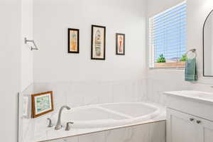 Full bath with a garden tub and vanity
