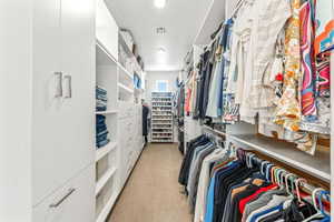 Walk in closet with light carpet