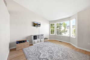 Living area featuring vaulted ceiling and light wood finished floors