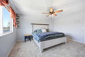 Bedroom with light carpet and a ceiling fan