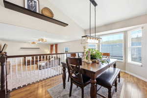 Dining room featuring light wood-type flooring and lofted ceiling