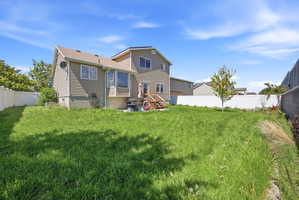 Rear view of house featuring a fenced backyard