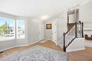 Entryway with light wood-type flooring and lofted ceiling