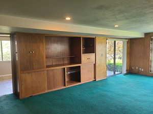 Unfurnished living room with dark carpet