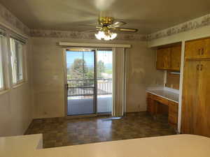 Unfurnished dining area featuring ceiling fan and built in desk