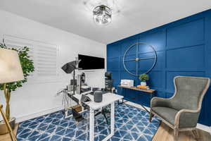 Office featuring a decorative wall and wood finished floors