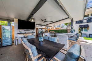 View of patio with exterior kitchen, a ceiling fan, and an outdoor bar and dining area