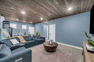 Living area with carpet flooring, wood ceiling, and recessed lighting