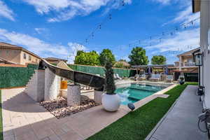 View of swimming pool with patio surround and a fenced backyard