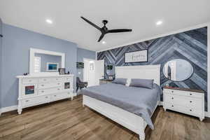 Bedroom featuring an accent wall, dark wood-style flooring, a ceiling fan, recessed lighting, and wallpapered walls