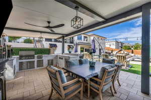 View of patio with an outdoor kitchen / dining area and ceiling fan