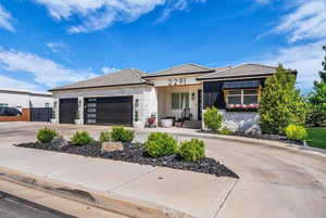 View of front of home featuring driveway, a garage, stone siding, stucco siding, and a tiled roof