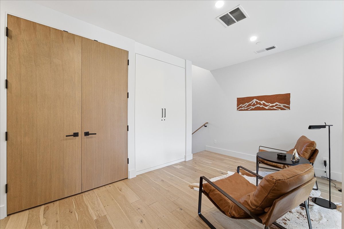 Sitting room with an upstairs landing, light wood-type flooring, and recessed lighting