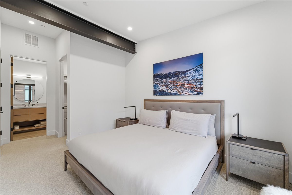 Bedroom with light carpet, ensuite bathroom, and recessed lighting