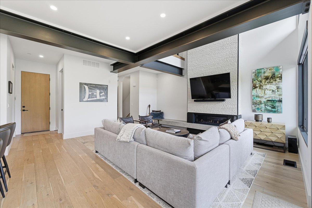 Living room featuring light wood-type flooring, recessed lighting, and a fireplace