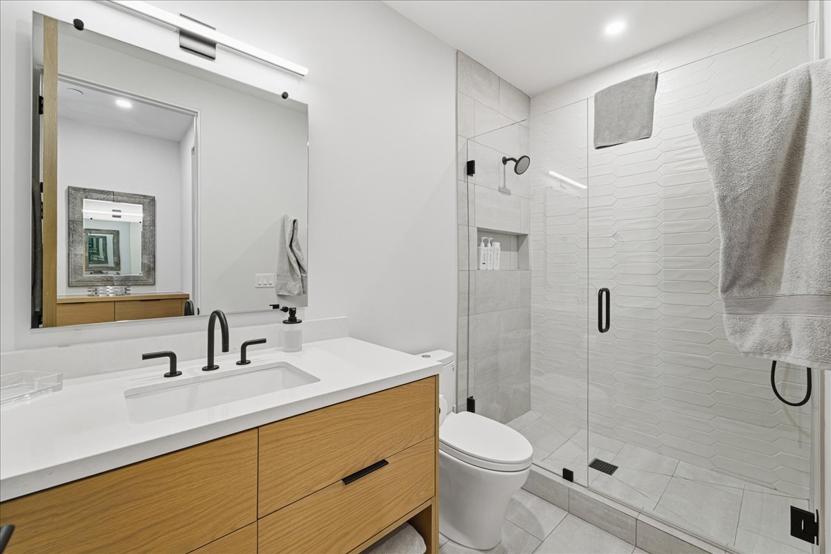 Bathroom with vanity, a shower stall, and recessed lighting
