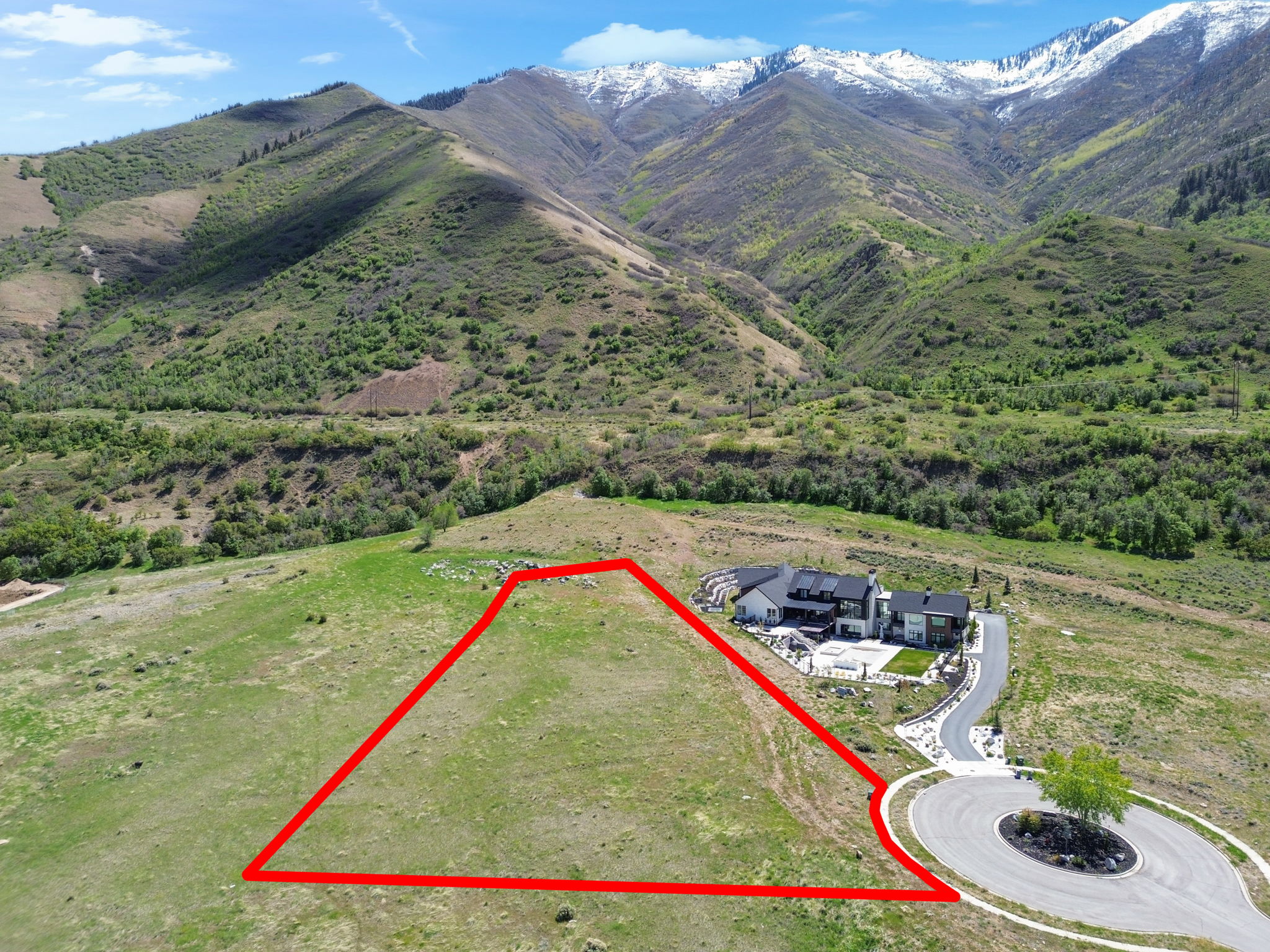 Aerial view of property and surrounding area with property boundaries highlighted and a mountainous background
