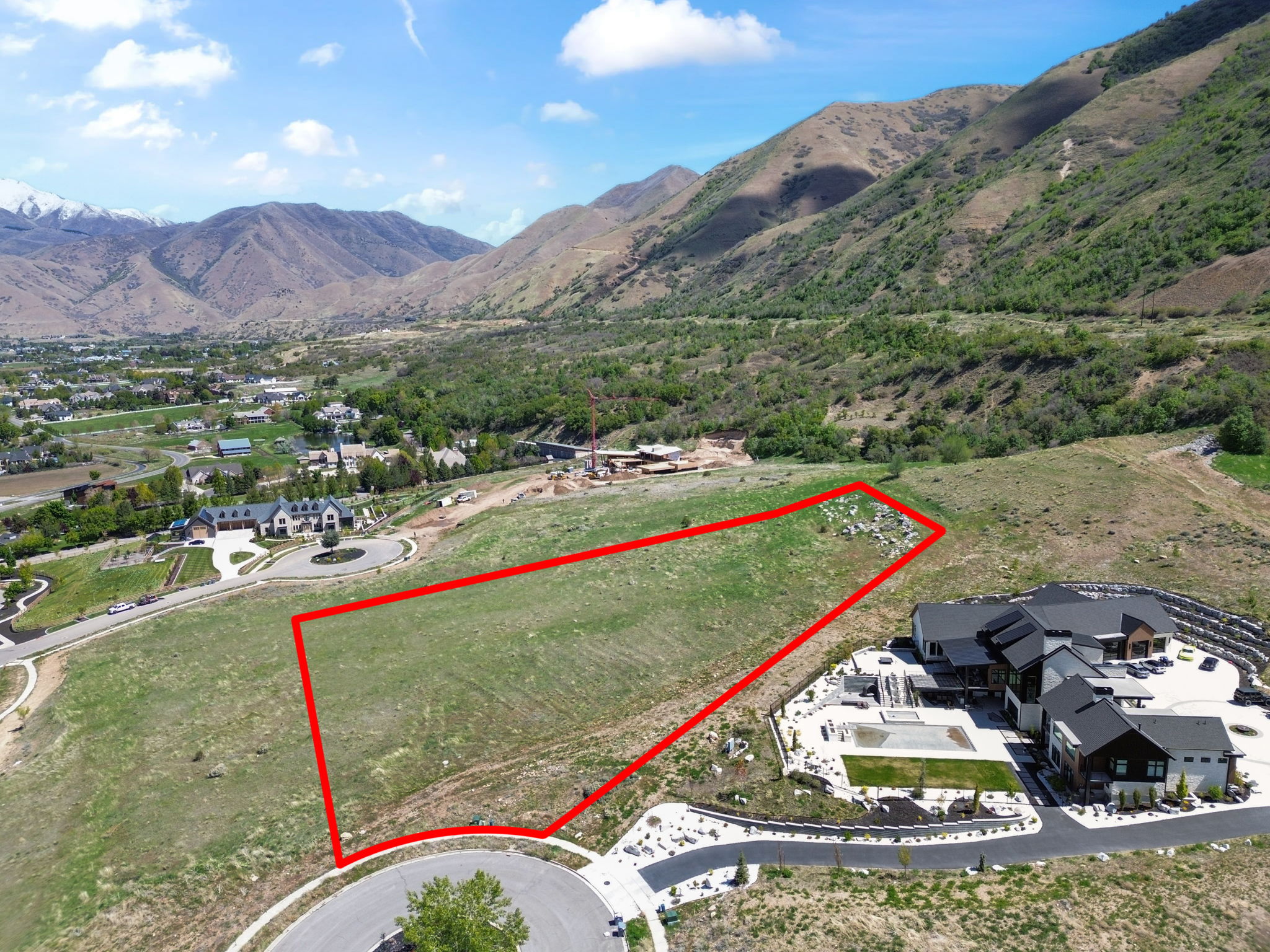 Aerial view of property and surrounding area with property boundaries highlighted and mountains