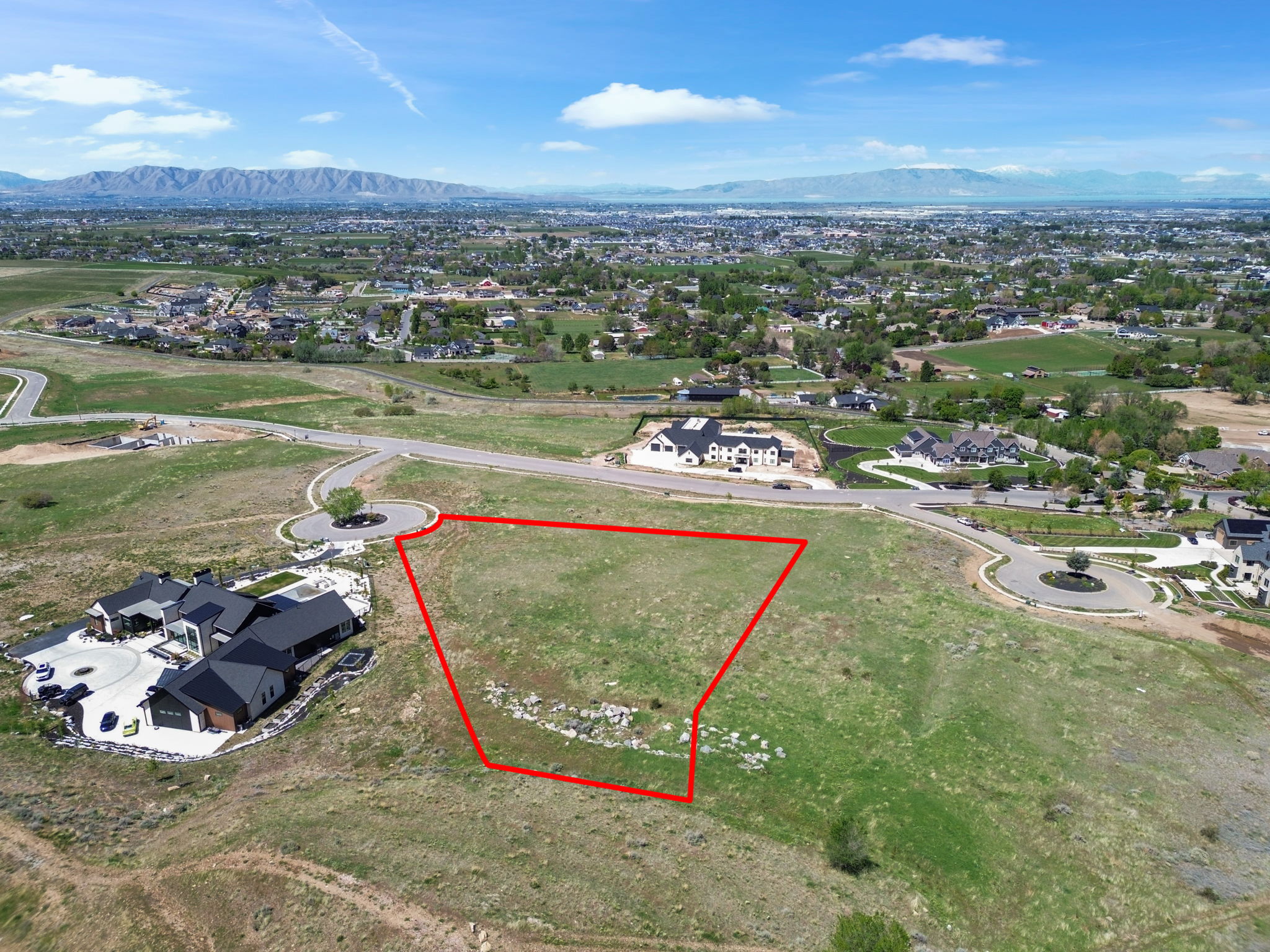 Aerial perspective of suburban area with property boundaries highlighted and a mountain backdrop