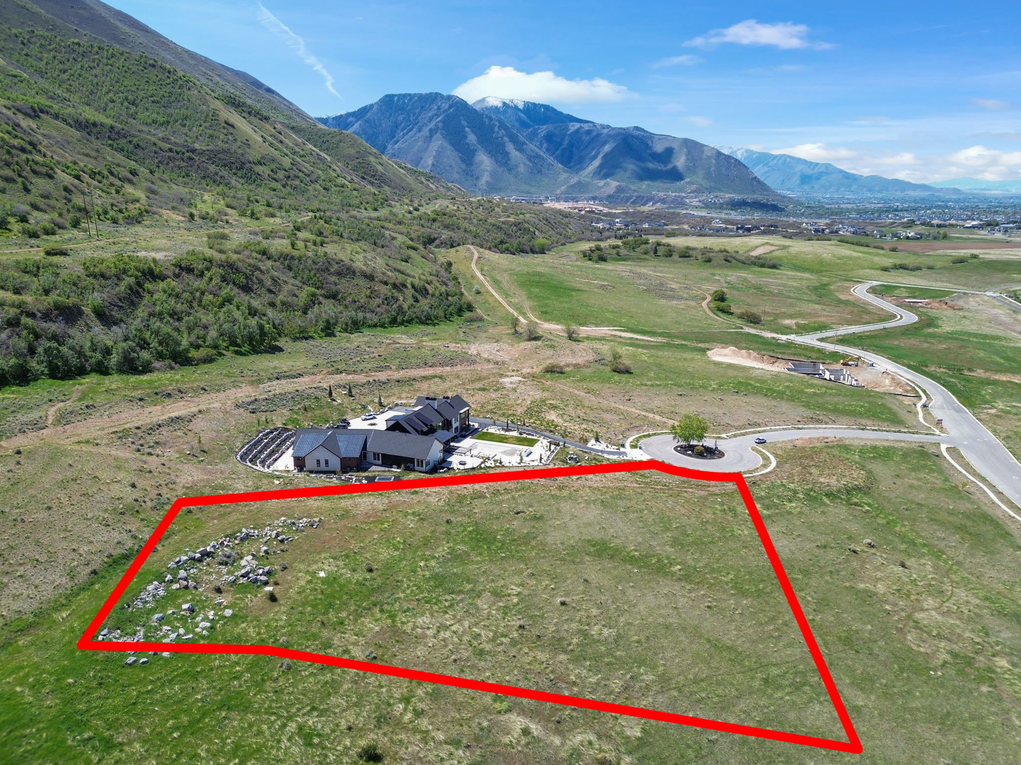 Aerial view of property's location with property parcel outlined and a mountainous background