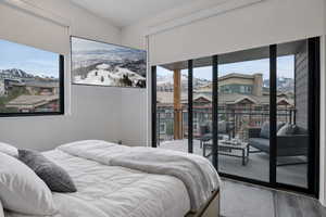 Bedroom featuring a mountain view, access to exterior, and wood finished floors