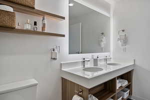 Full bathroom with double vanity and toilet