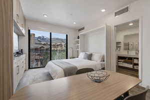 Bedroom with access to outside, light wood-style flooring, and recessed lighting