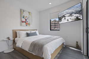 Bedroom featuring dark wood-style floors and baseboards