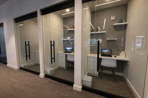 Office with built in study area and dark wood-style flooring