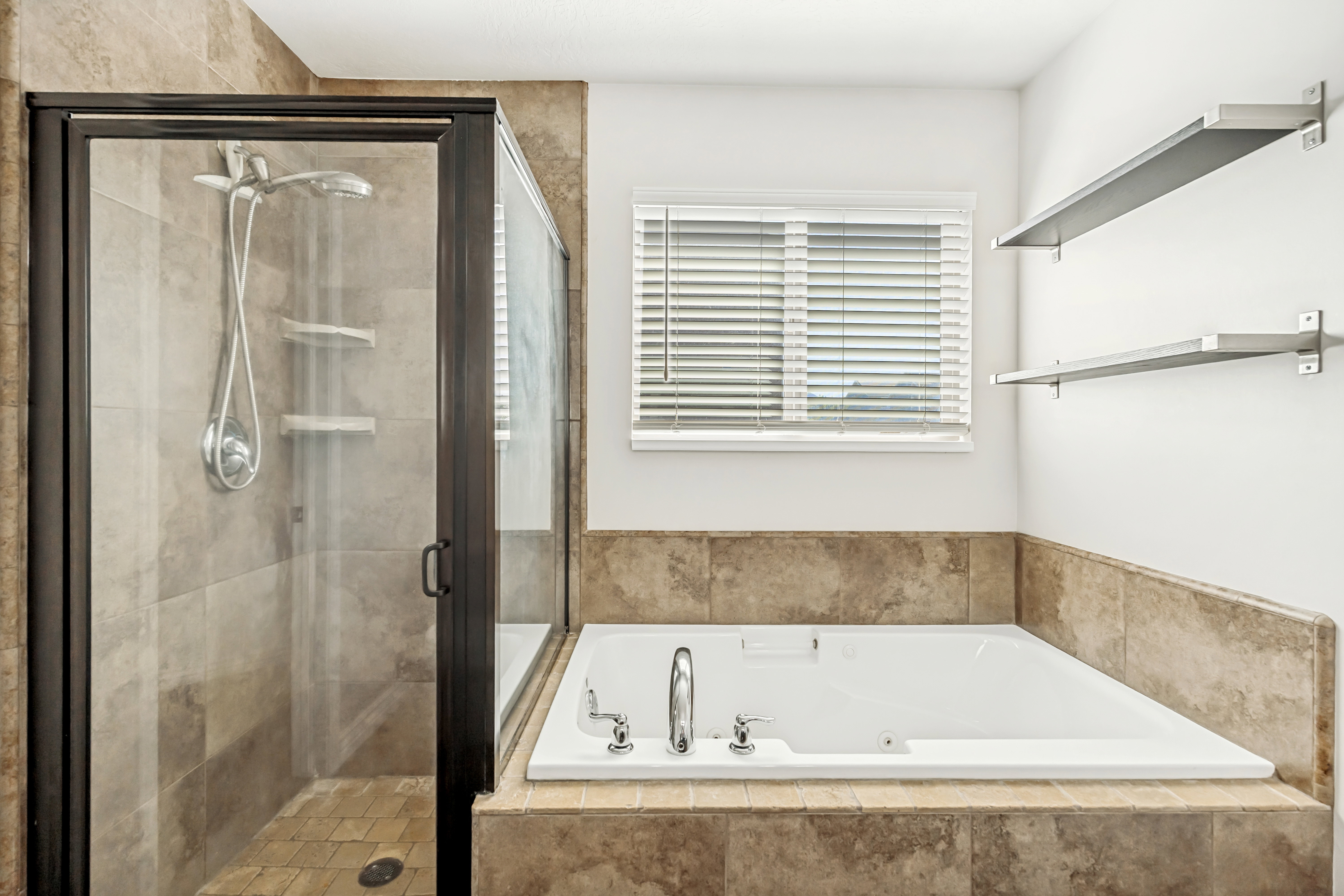 Full bath with a shower stall and a jetted tub